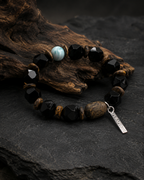 Unisex black agate bracelet displayed on dark stone and natural wood