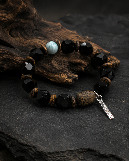Unisex black agate bracelet displayed on dark stone and natural wood