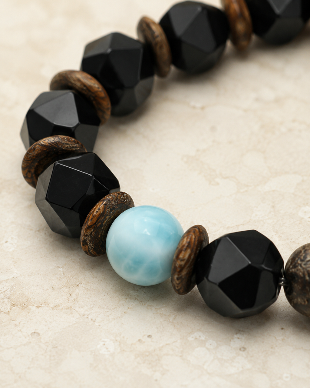 Close-up of 10 mm faceted black agate beads and wood spacer beads